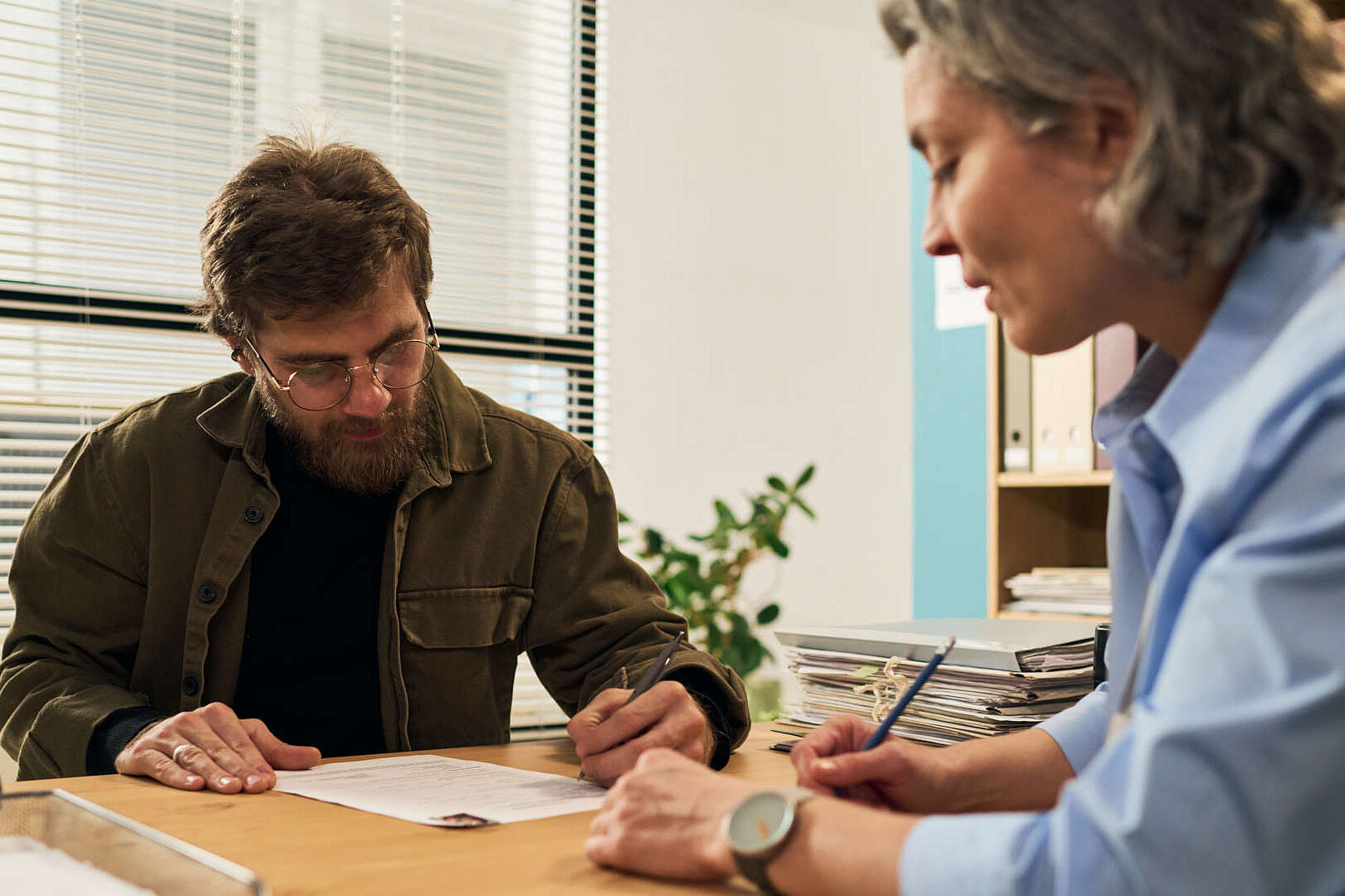 Beratungssituation mit einem Mann und einer Frau am Tisch