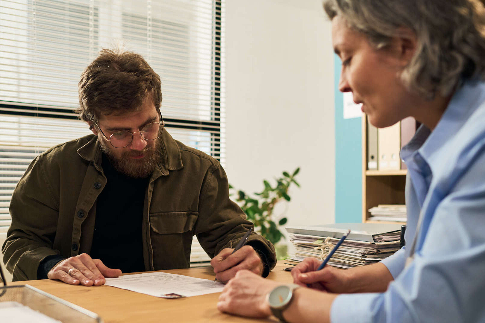 Beratungssituation mit einem Mann und einer Frau am Tisch