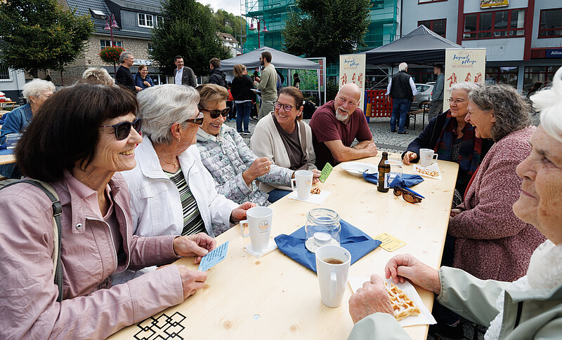 Mehrere Menschen unterhalten sich beim Suppenschätzchen an einem Tisch.